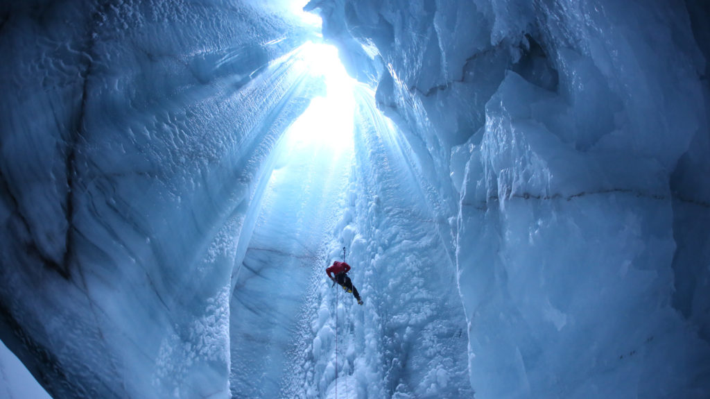 researchers climbing out of moulin